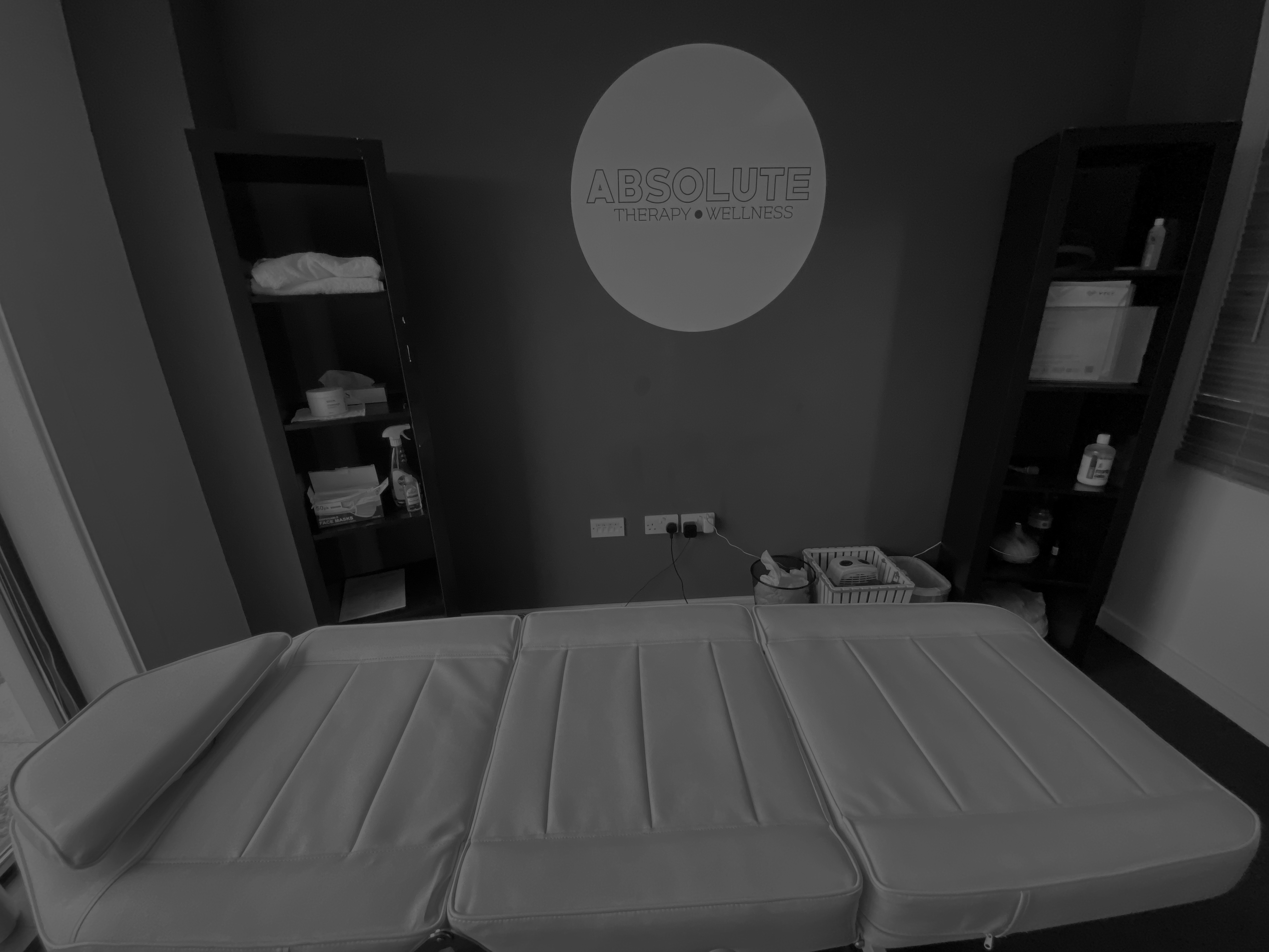 Absolute therapy room showing a bed with the sign on the wall